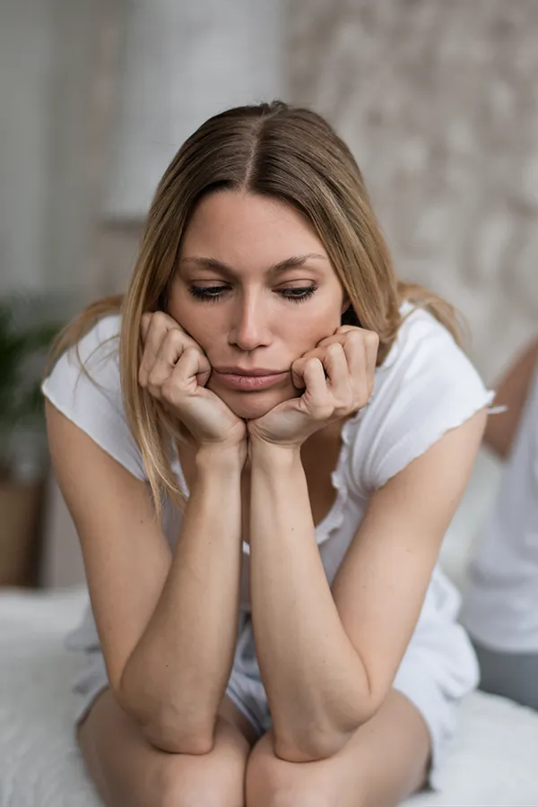 sexual-wellness-doctor-for-women A melancholy woman sits with her head in her hands. Get sexual wellness treatment from Richard Conlen, MD, FACOG in Boca Raton.